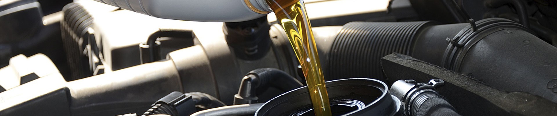 New gold-colored motor oil poured into a car engine