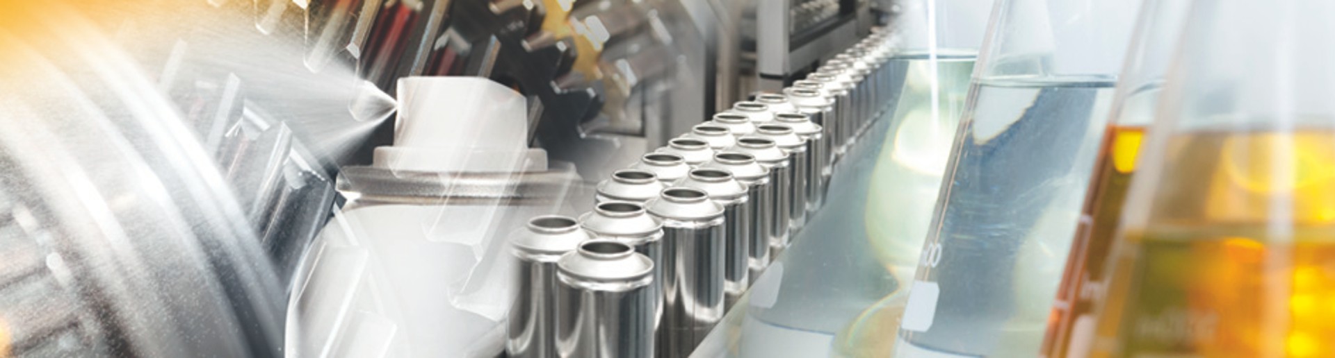 Filling line for aerosol spray cans, test tubes filled with yellow and white liquid and a  helical gear placed near by